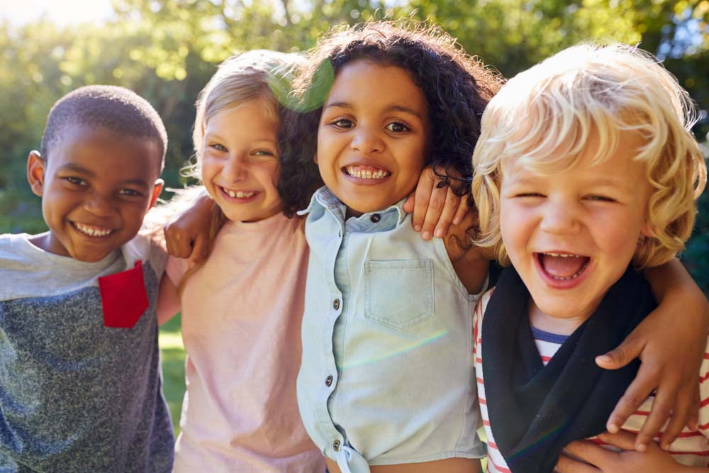 Diverse group of smiling children showing healthy teeth.