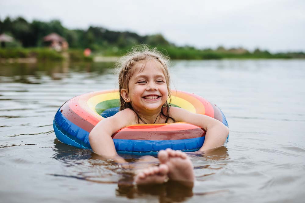 Child splashing water representing joyful, healthy smiles.
