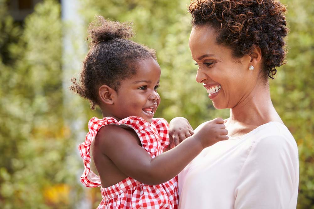 Mother and toddler smiling during a positive dental experience.