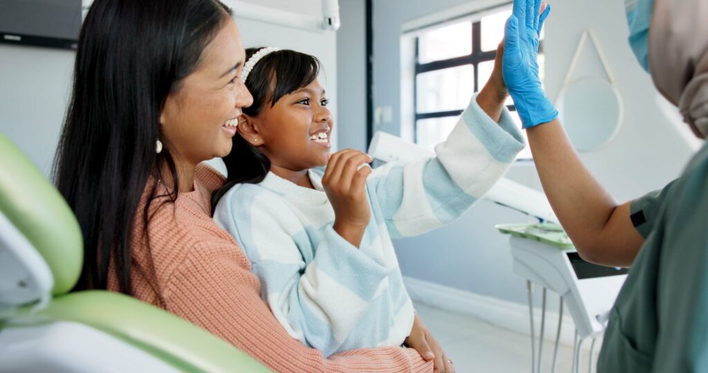 little girl giving the dentist a high five