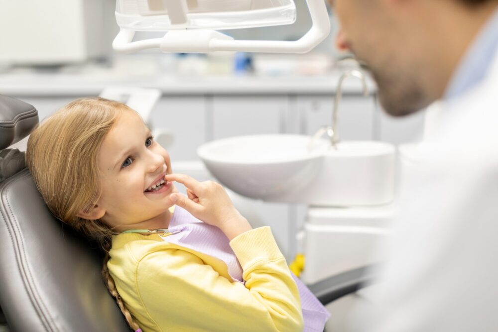 little girl showing baby teeth