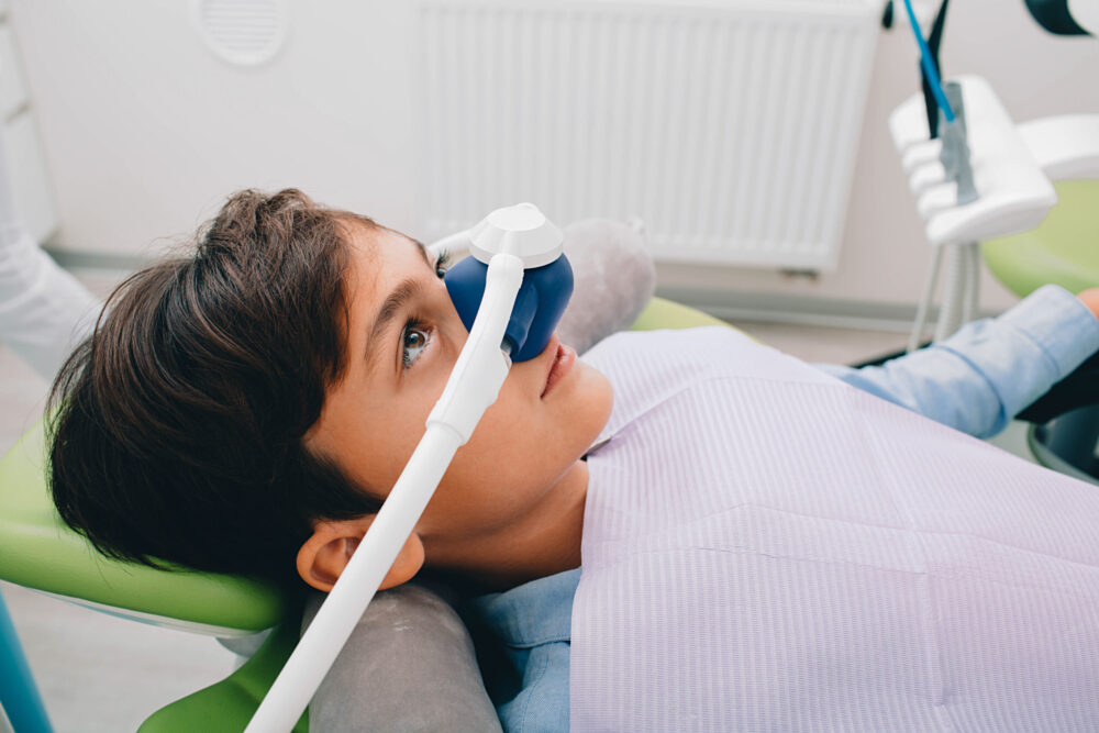little boy getting sedation during dental treatment