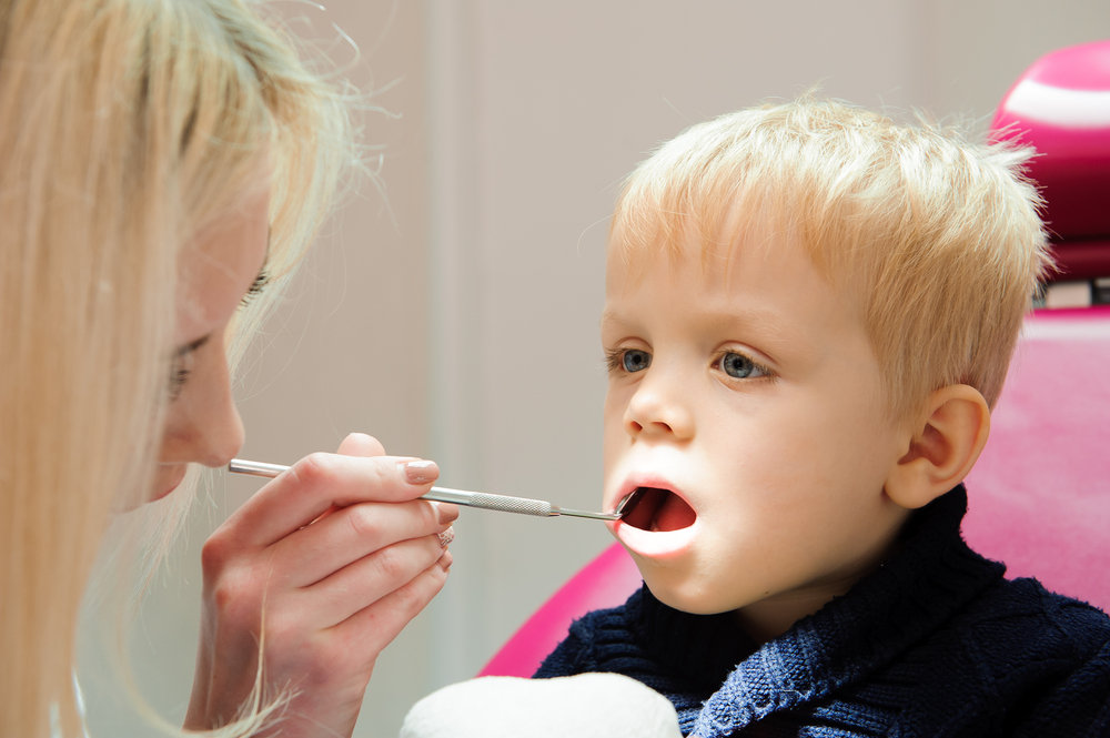 pediatric dentist inspecting patient